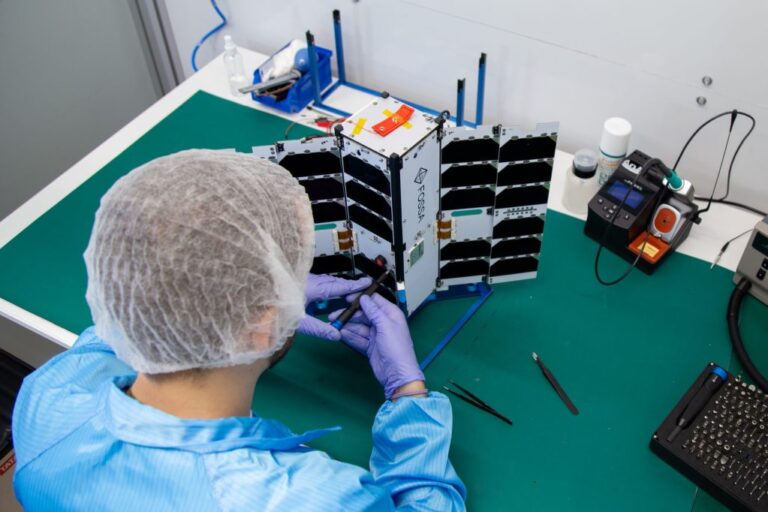 person-working-on-a-FOSSASat-3U-scaled.jpg