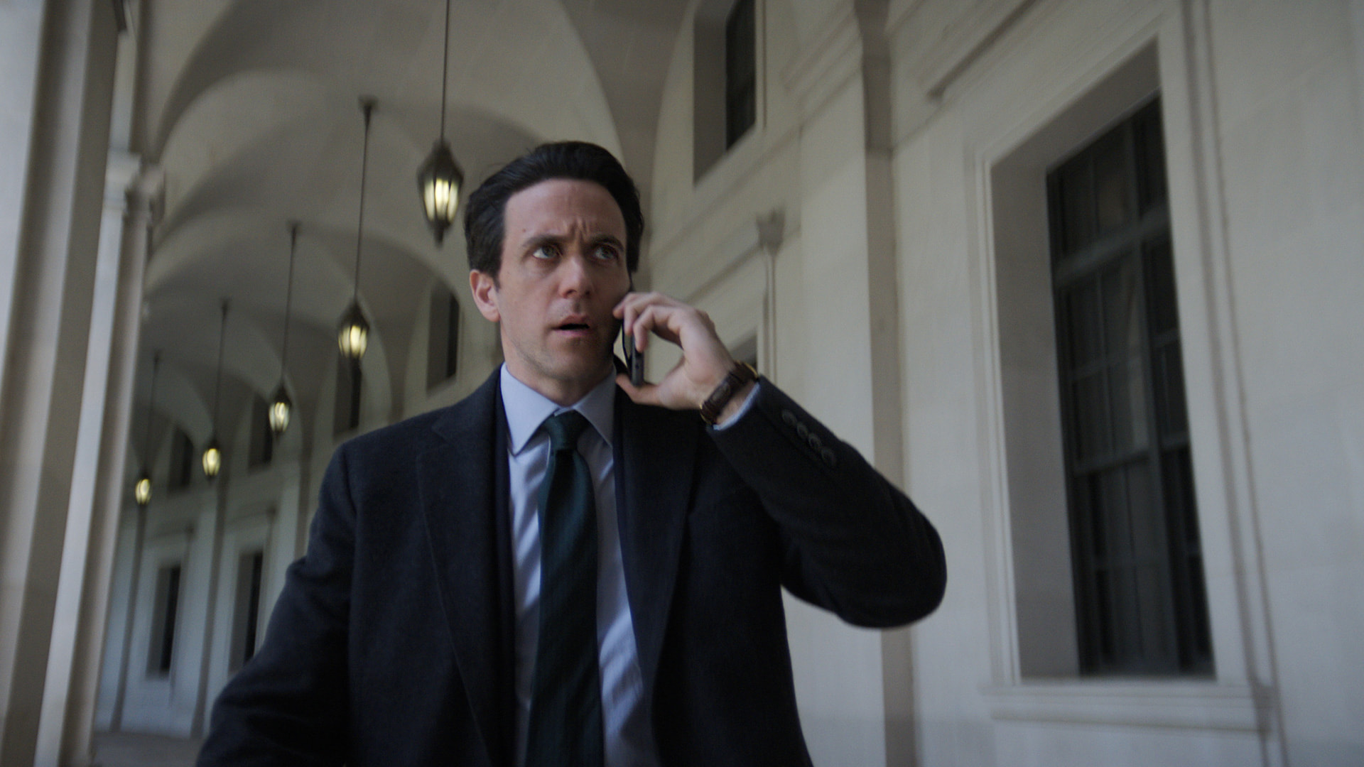 a man in a business suit talking on a cell phone