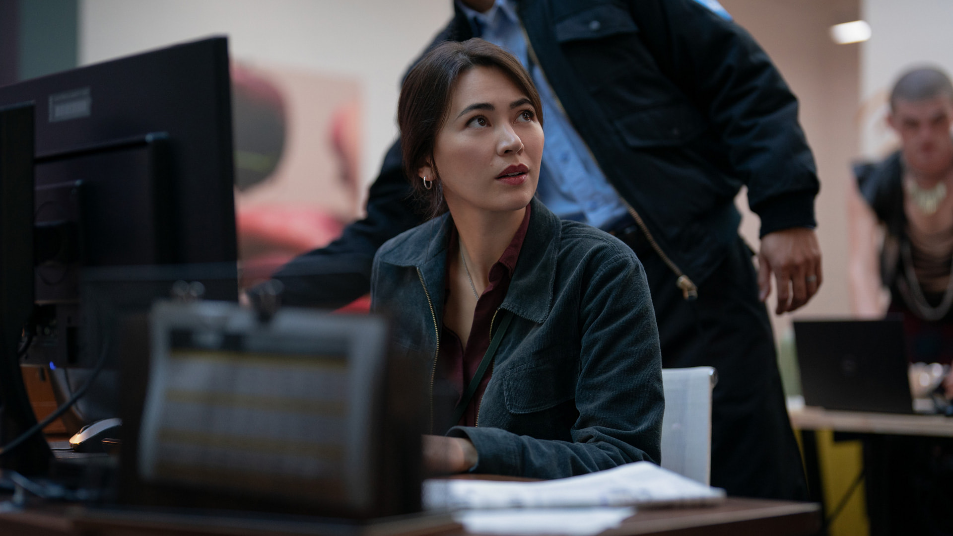 a woman sitting at a computer desk in an office