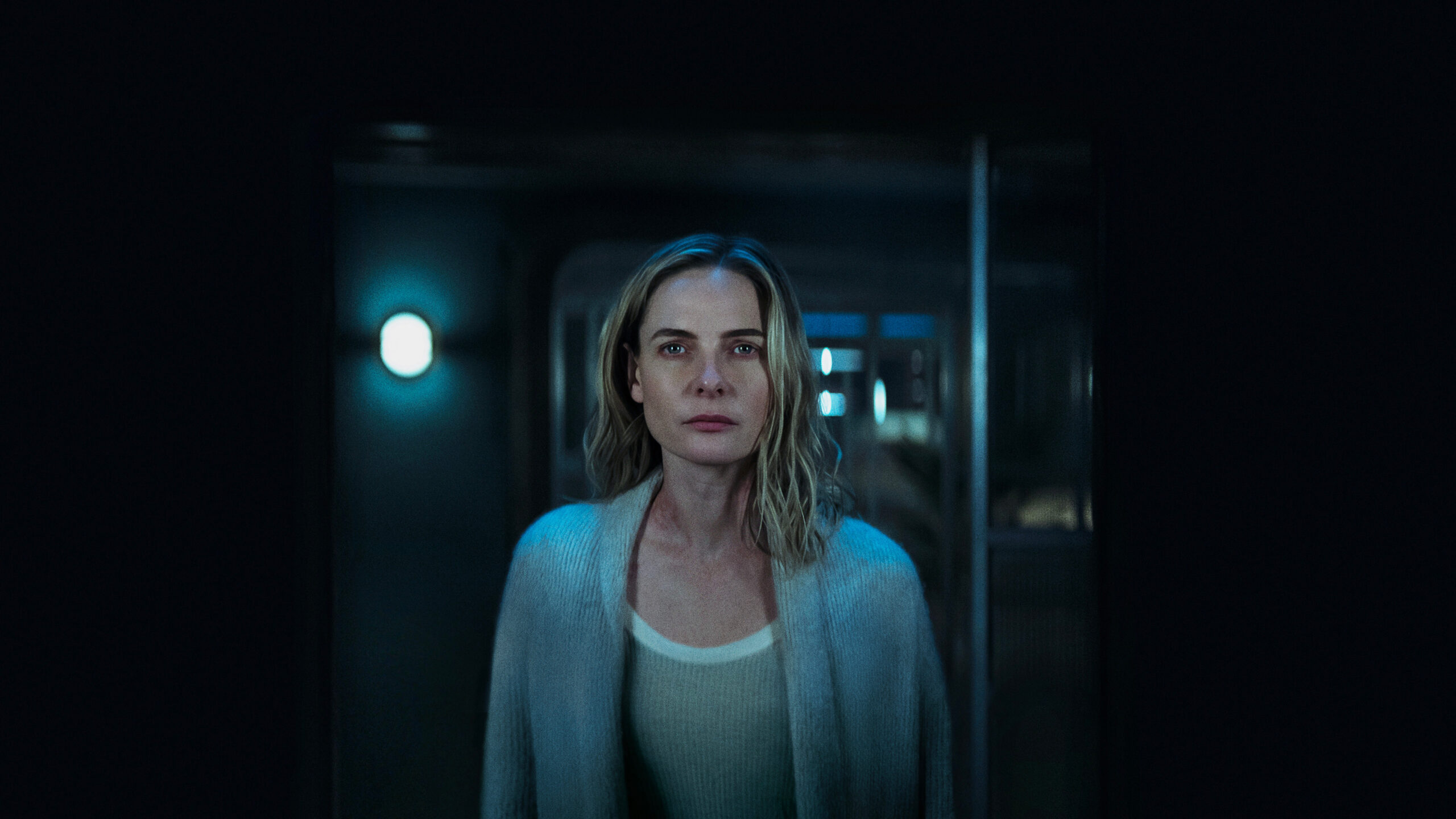 a woman in a sweater staring into a mirror