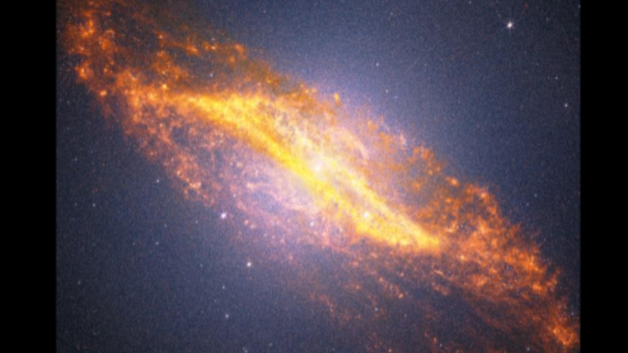 A blueish purple view of space with a bright yellowish structure in the center going diagonally from the top left to the borrom right.