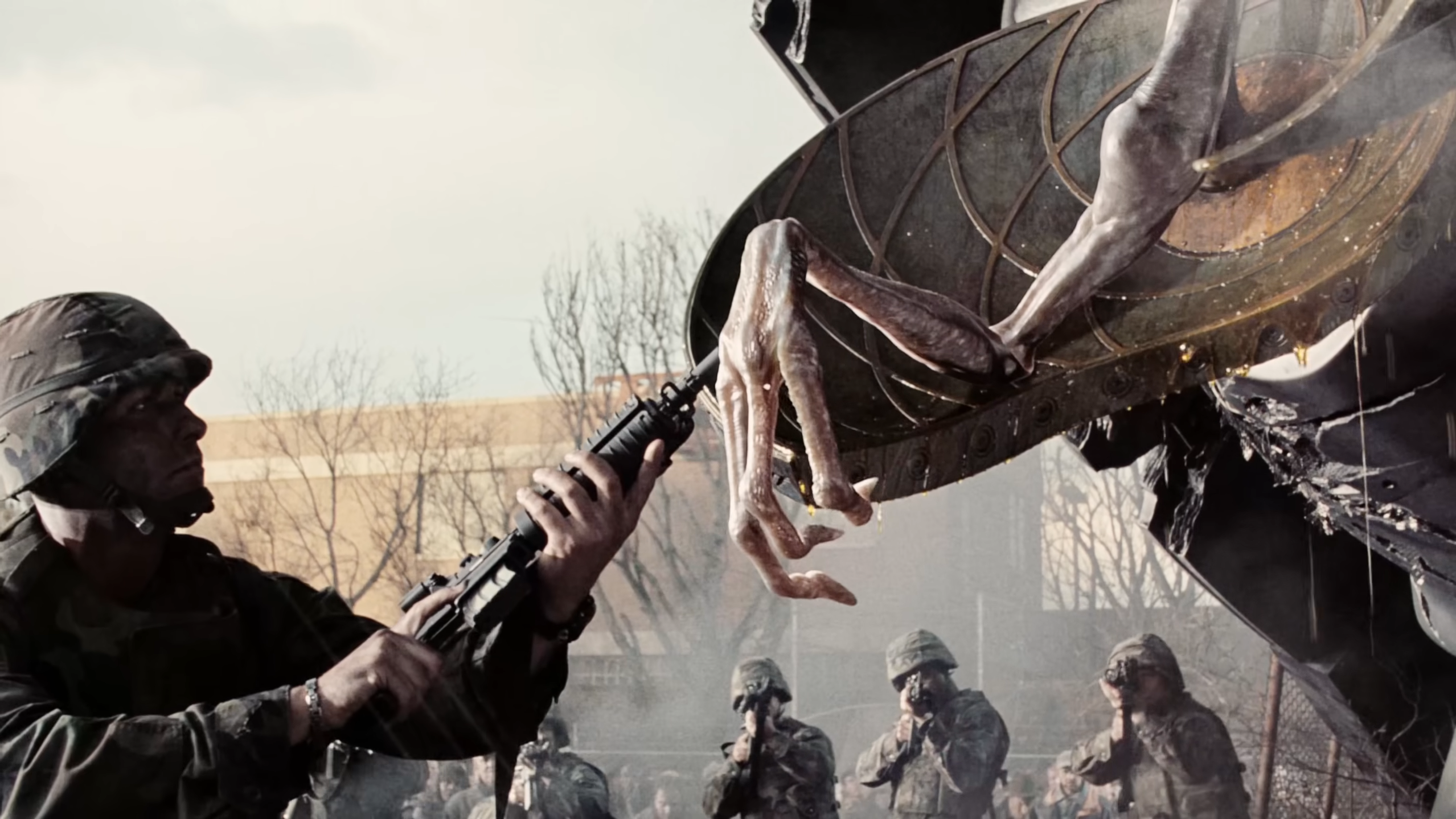 A soldier inspects a dead alien in War of the Worlds