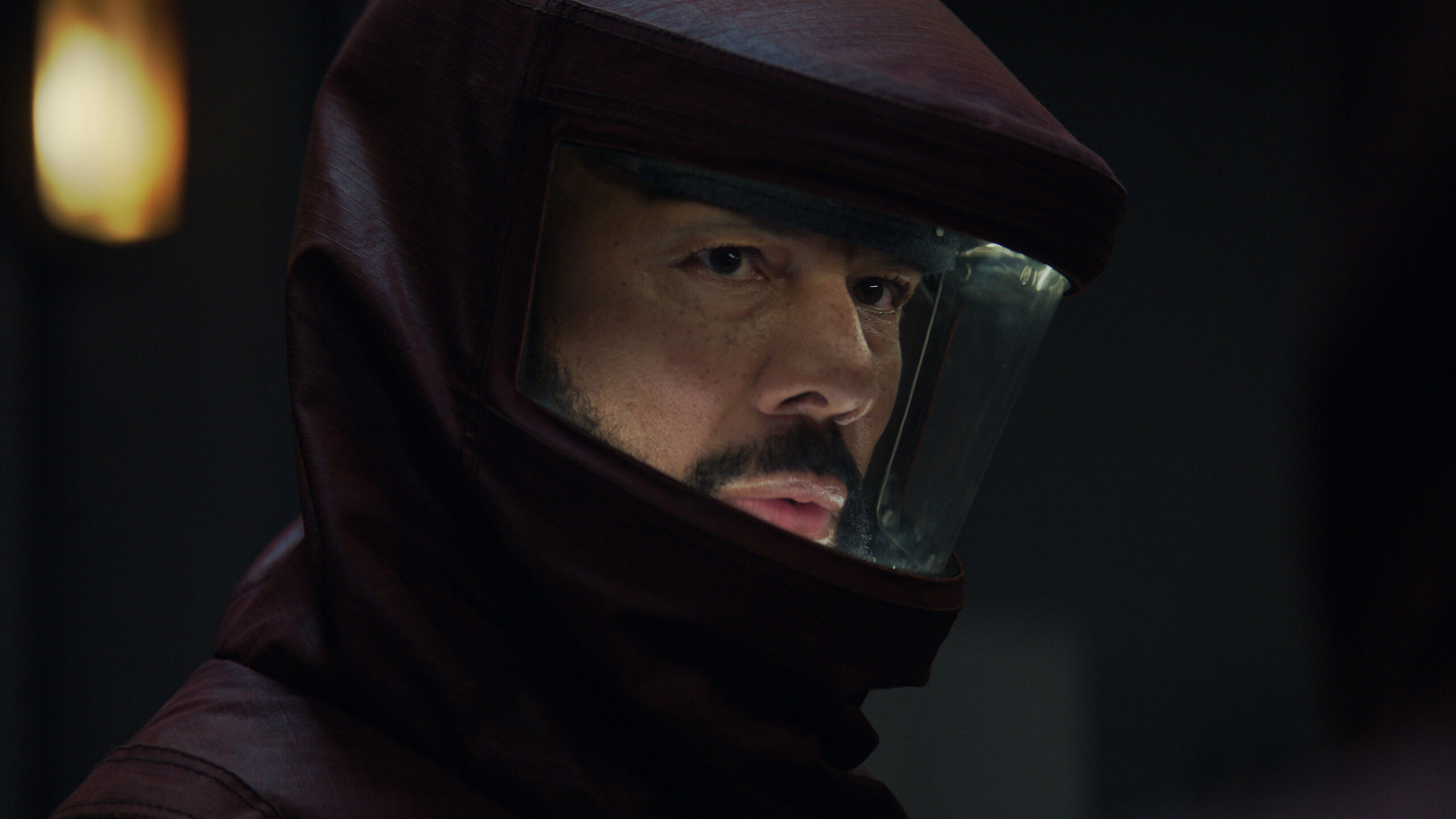 a man wearing a dark red hazmat suit