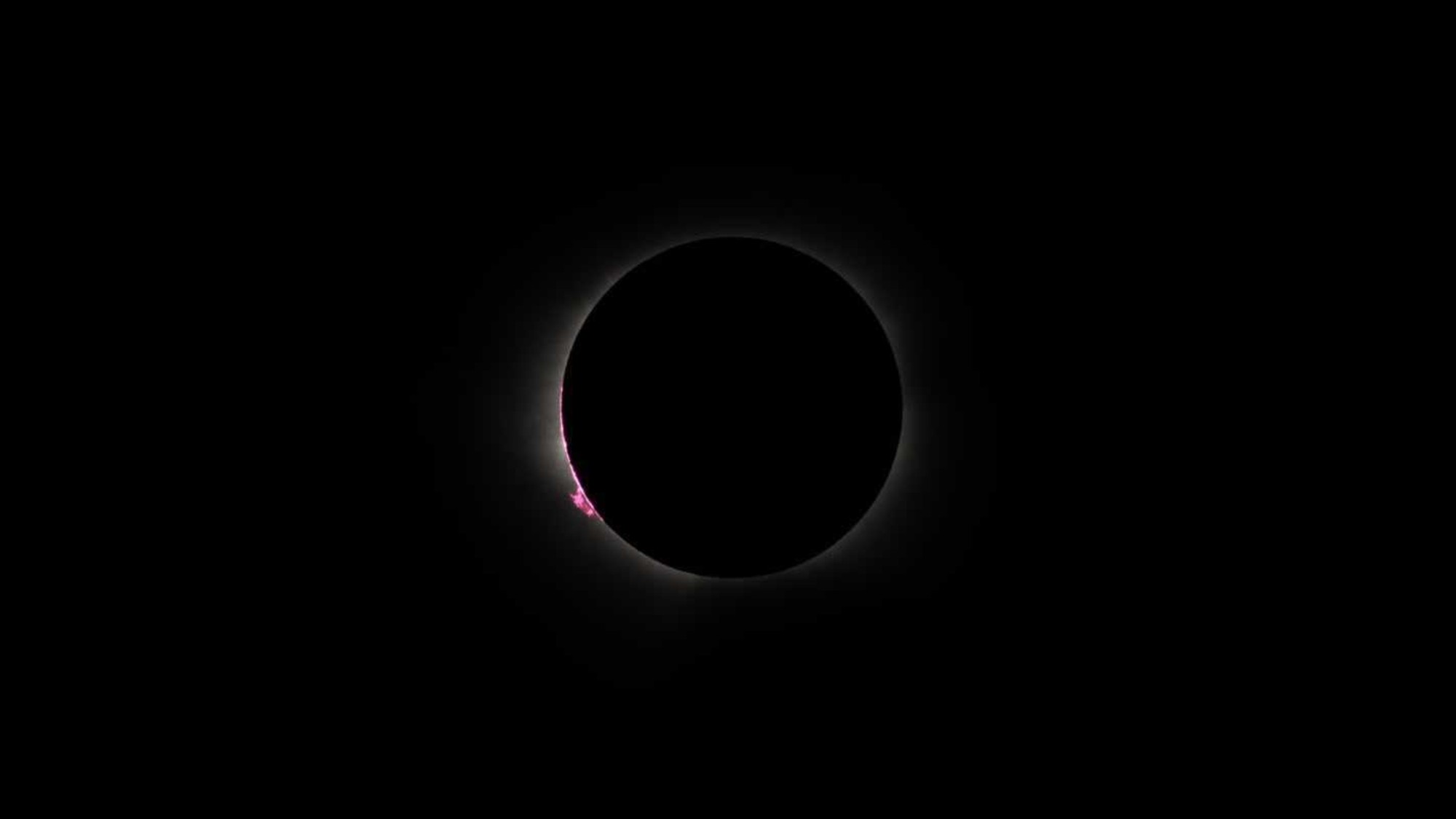 a thin white line of wispy light on a black background