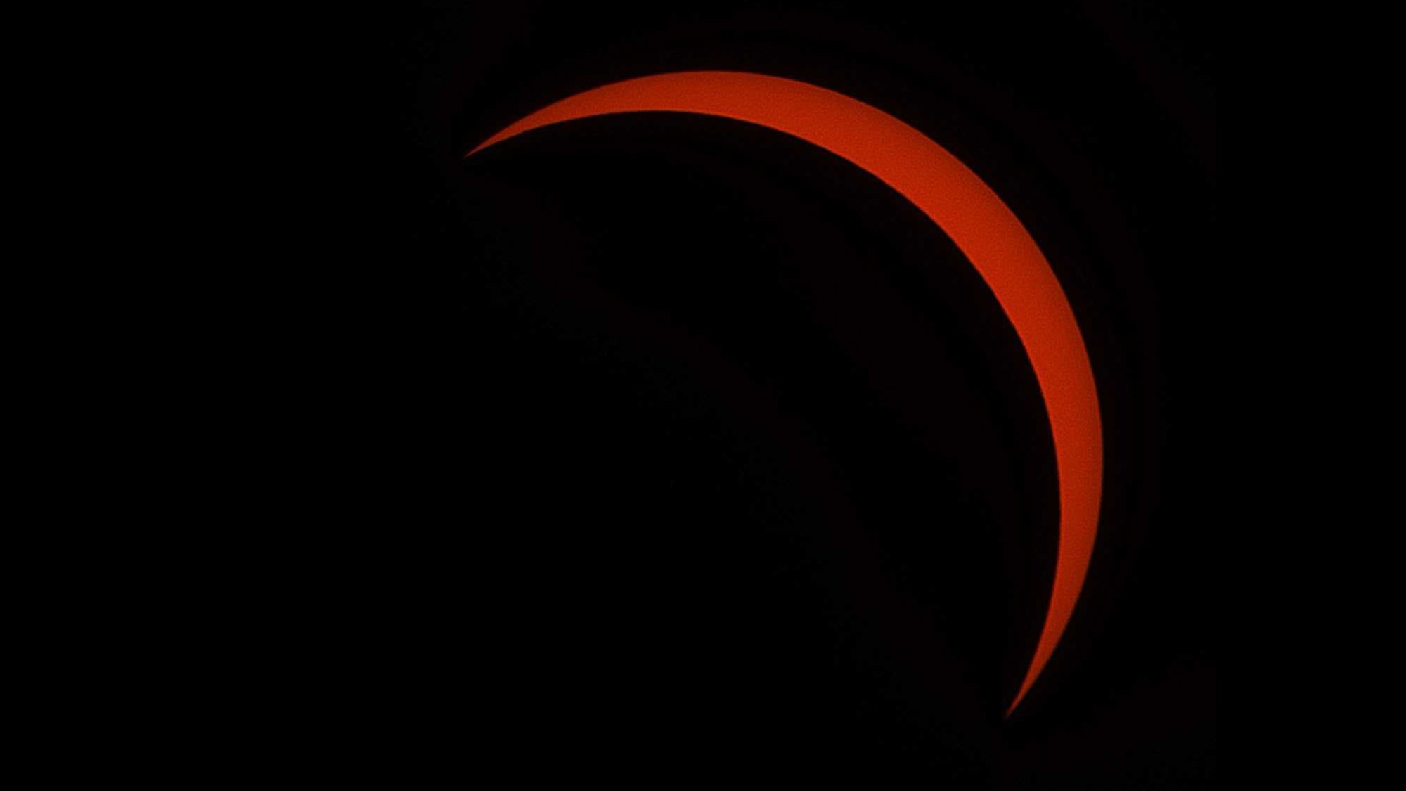 a thin red crescent on a black background