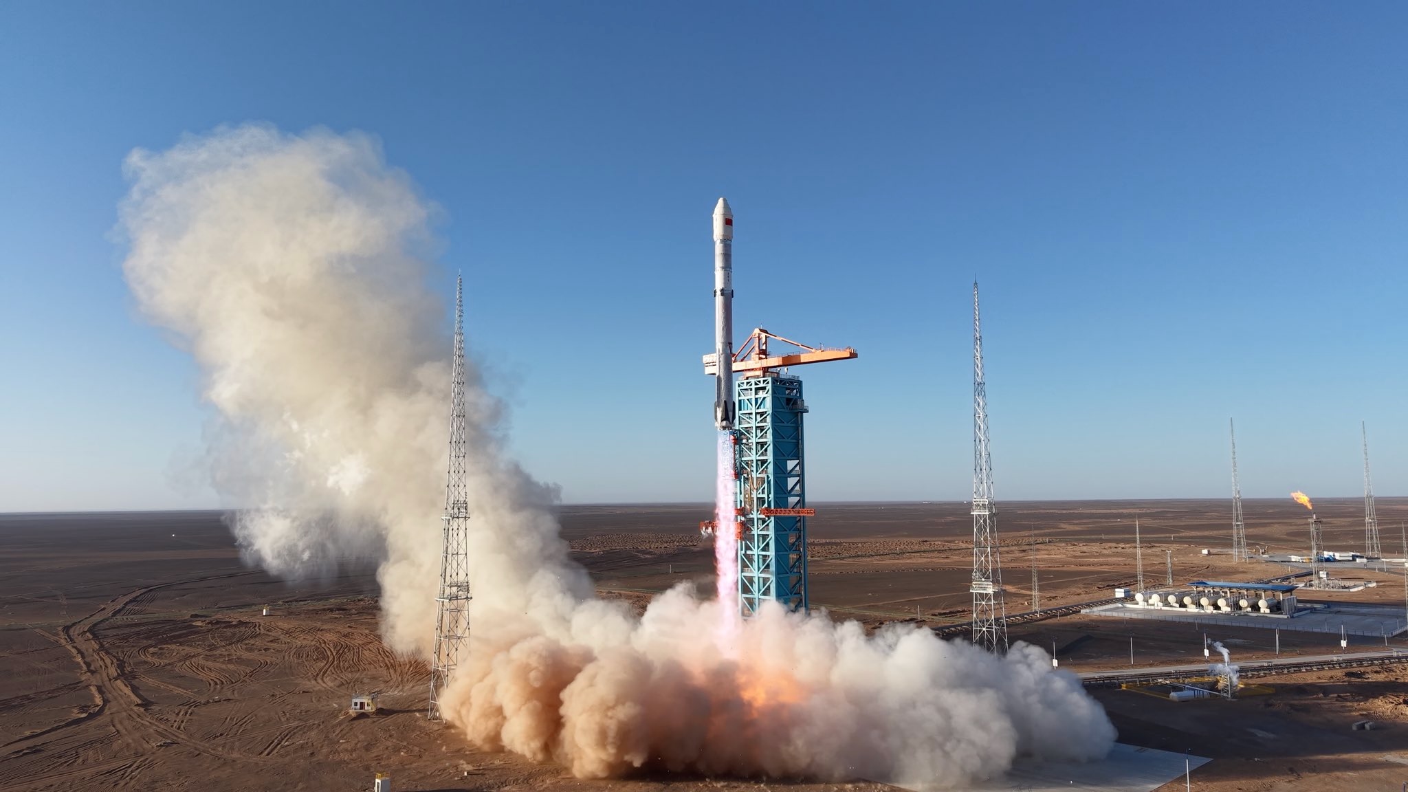 a white and red rocket launches from a desert spaceport