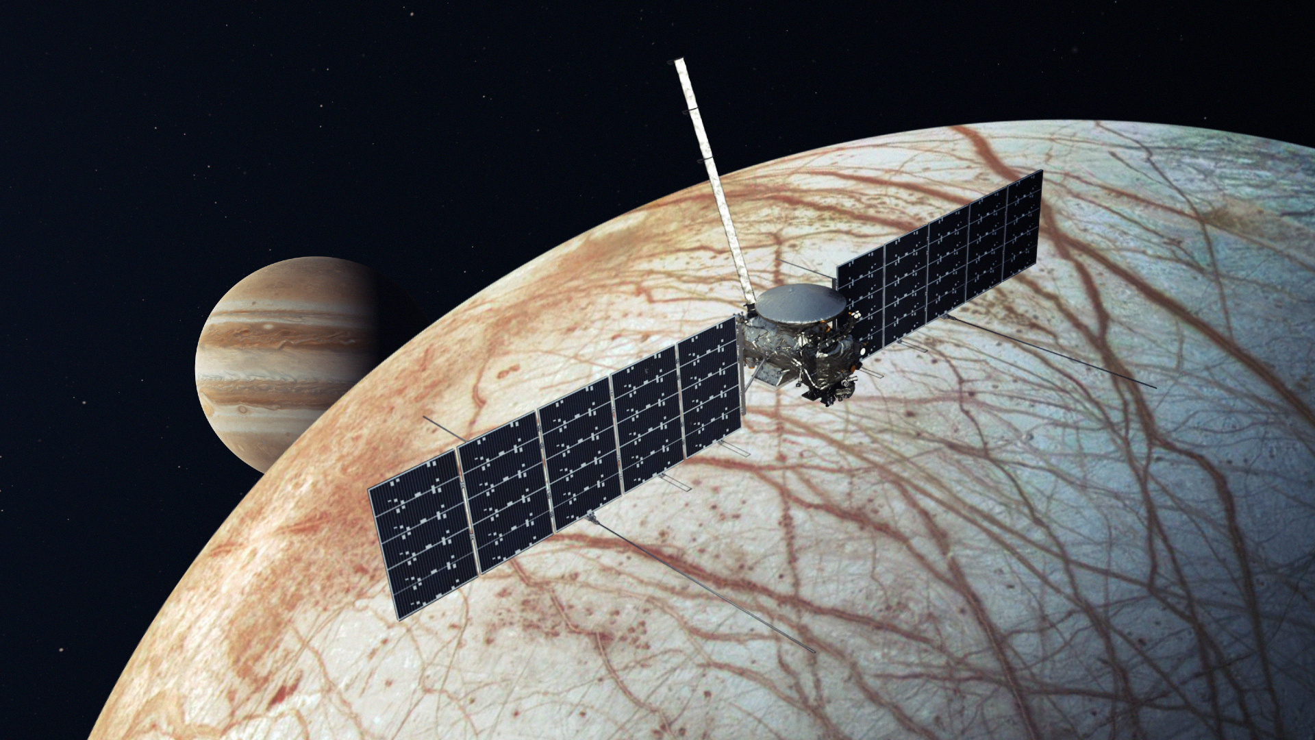 A small spacecraft with solar panel wings flying above a white world with some streaks of reddish orange on it. In the back, you can see Jupiter.