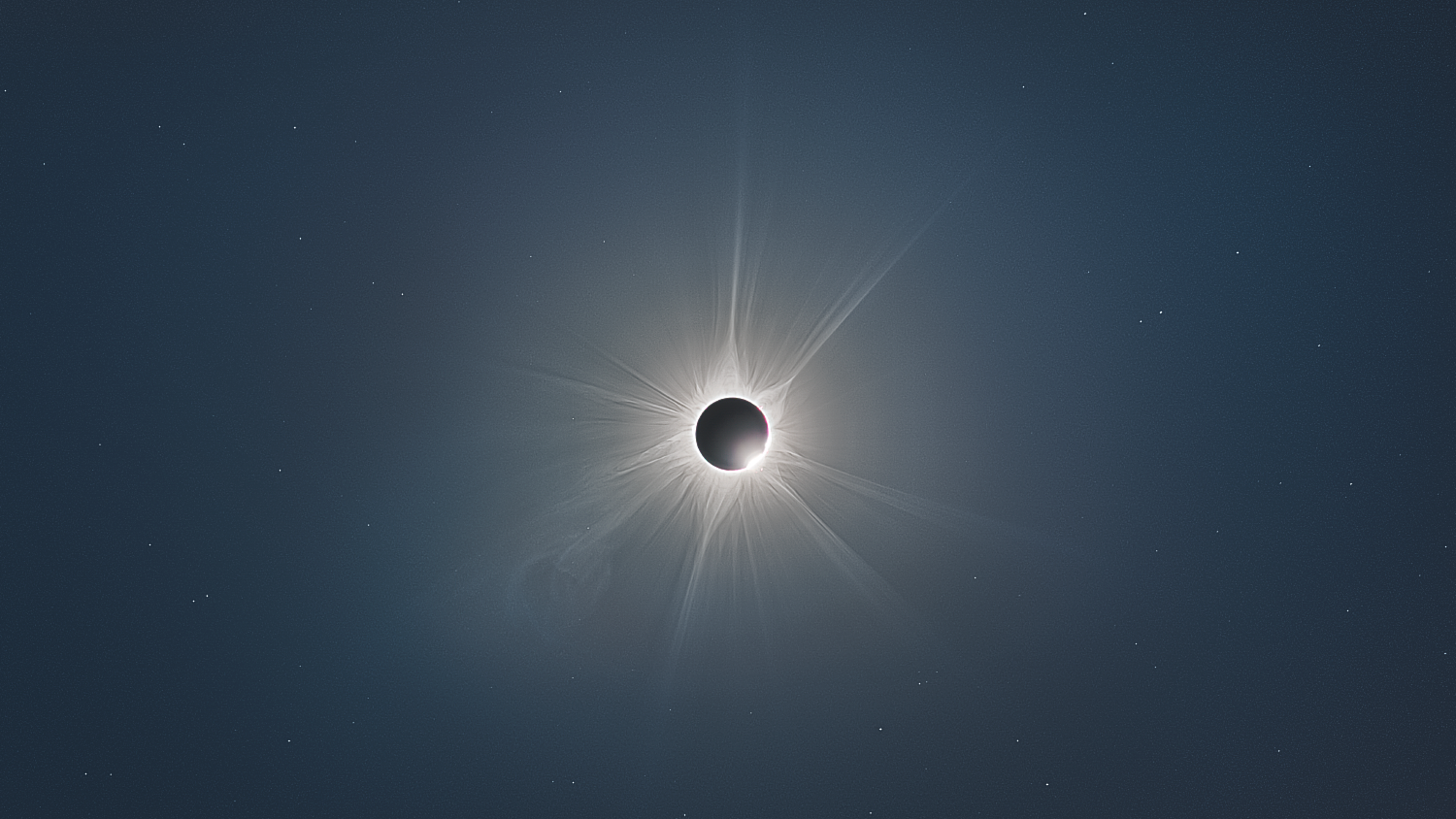 view of sun during totality with distinct white streamers streaking out from the sun - this is the corona.