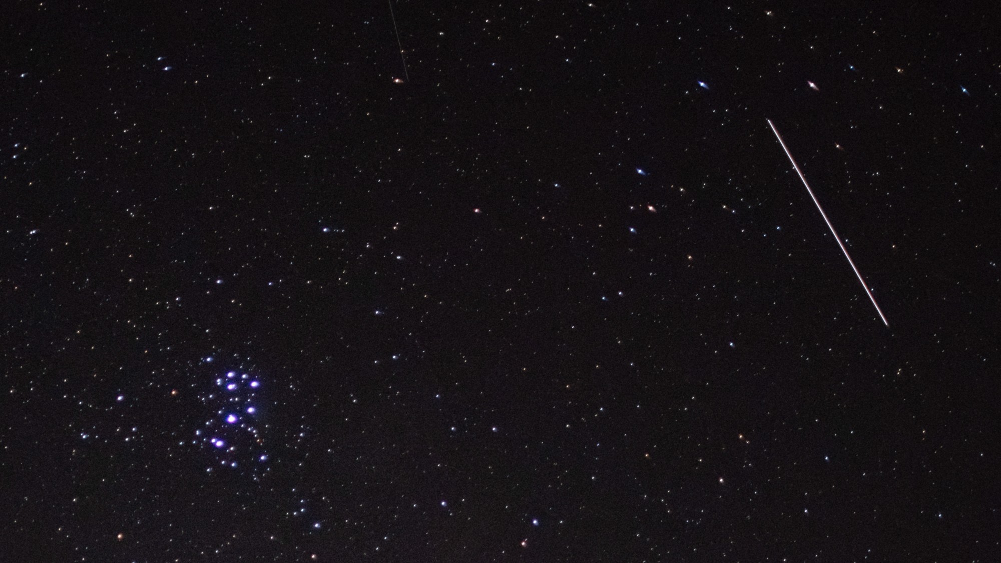 a streak of light crosses through the night sky