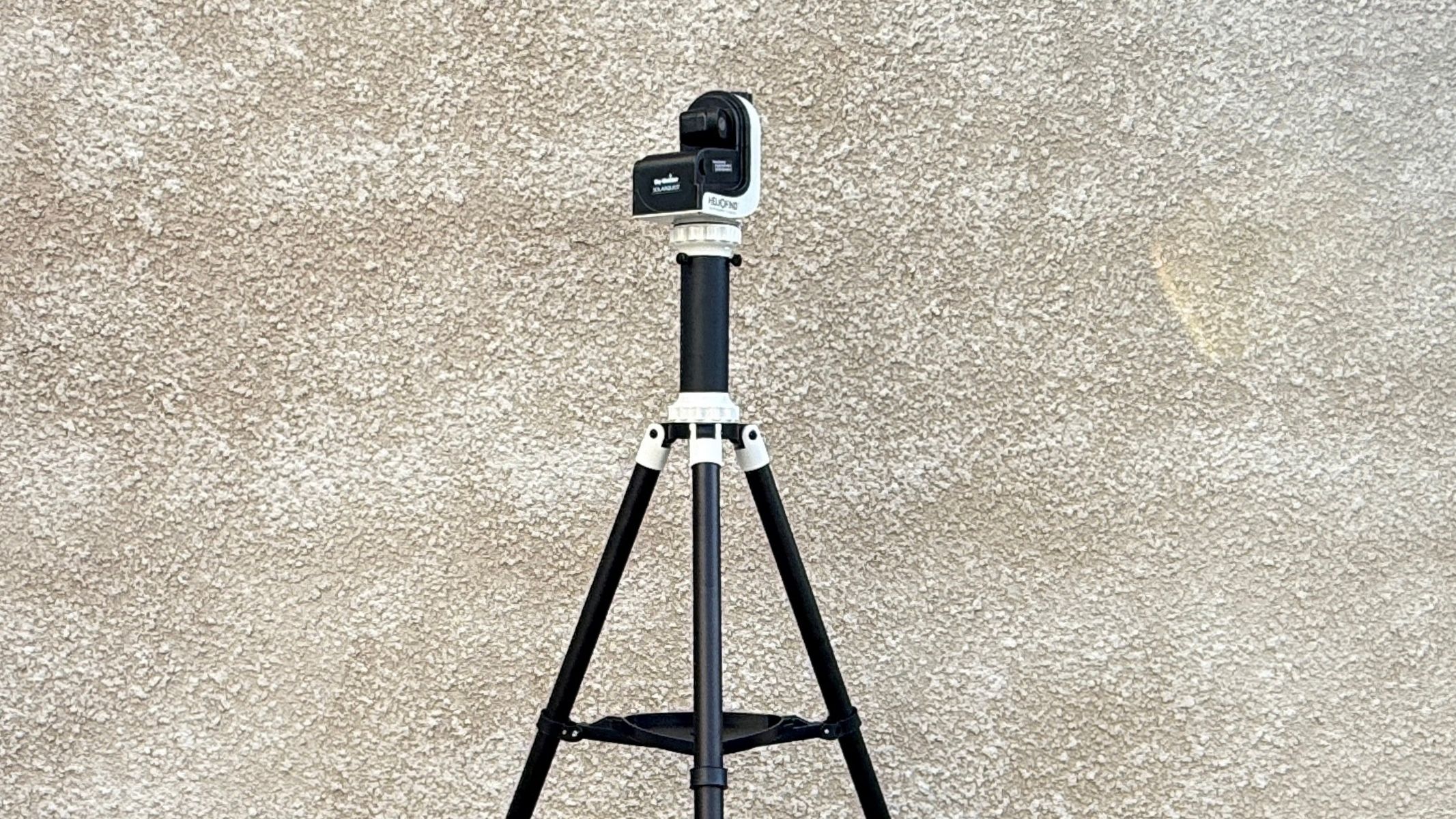 The Sky-Watcher SolarQuest solar telescope mount and tripod against a textured white wall.