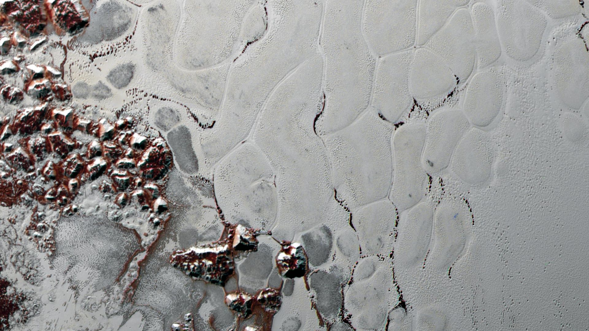 A view of white sections of a world with some reddish areas toward the left.