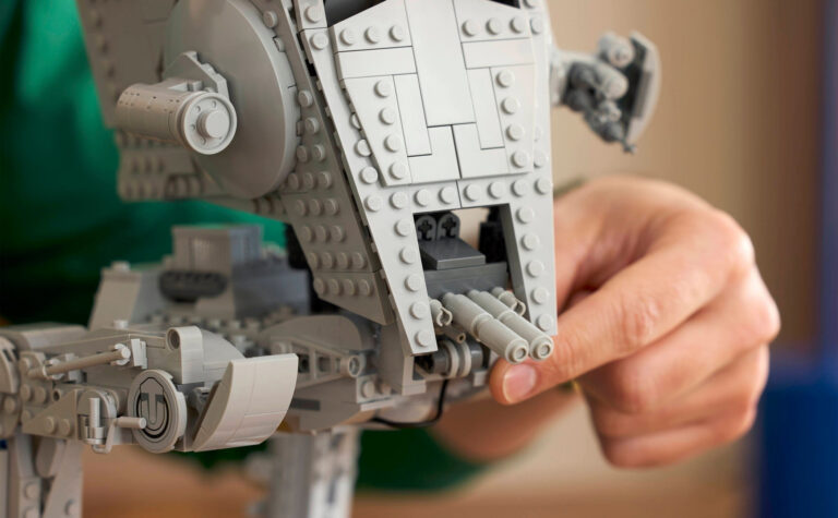 A close up of a Lego Star Wars AT-ST Walker 75417 set, with a hand moving the front guns.