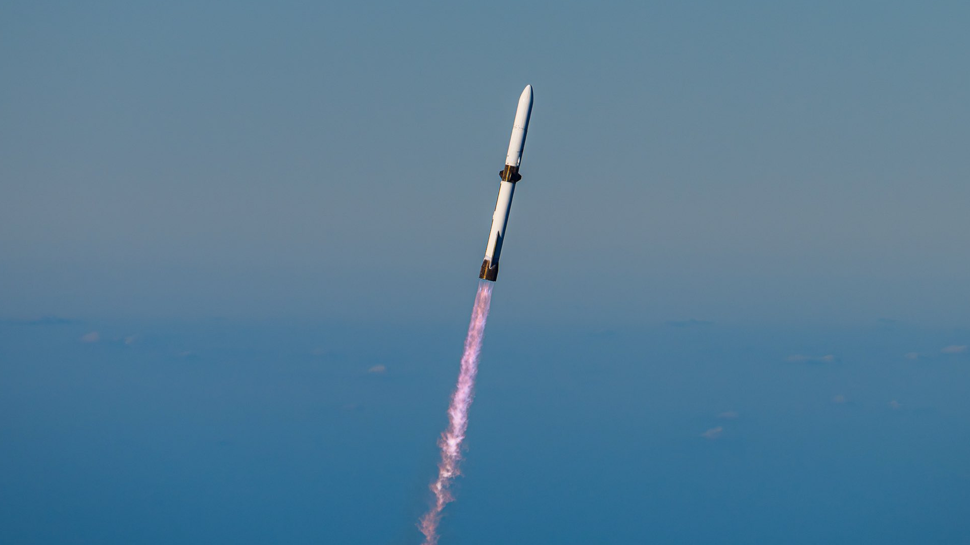 a large white rocket flies through a blue sky