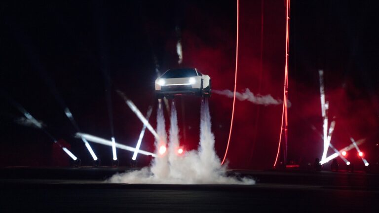 a car hovers about 15 feet off the ground, with three plumes of white gas from thrusters coming out of its chassis